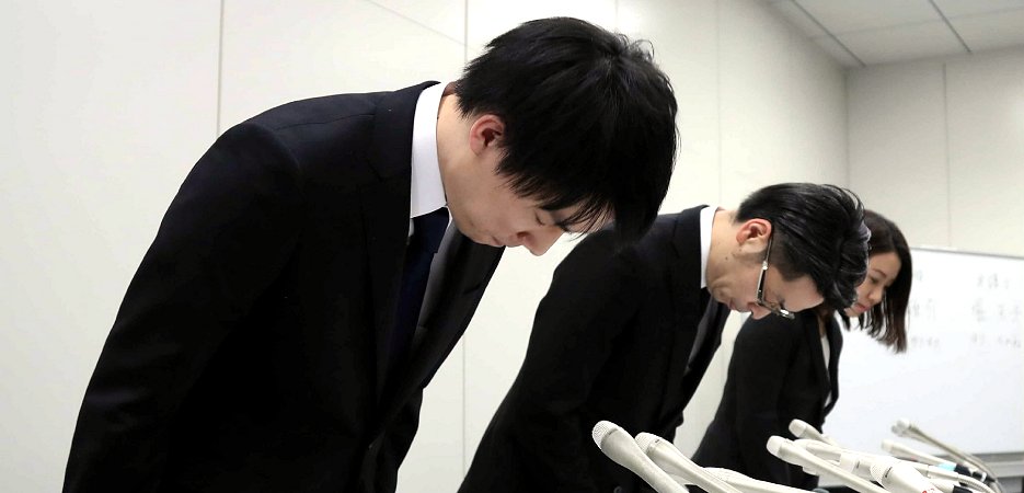 記者会見で頭を下げるコインチェックの和田晃一良社長（左）ら（26日、時事）