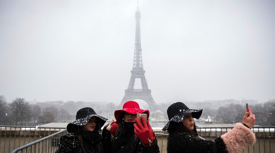 雪景色にかすむパリのエッフェル塔（5日、AFP＝時事）