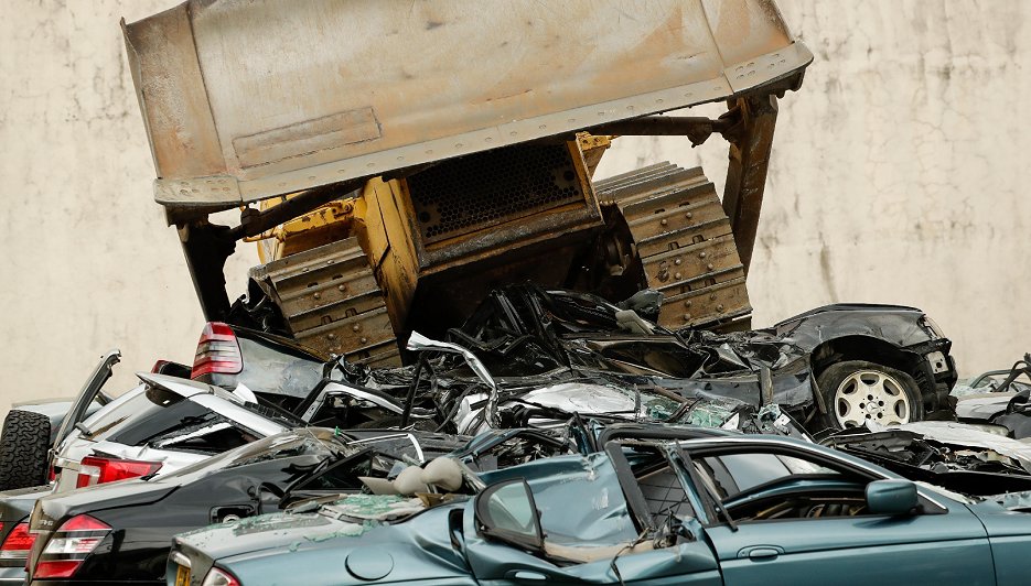 マニラでブルドーザーにつぶされる密輸品の高級車（6日、EPA＝時事）