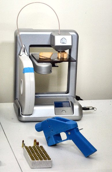 3Dプリンター（奥）で製造された銃（手前）（13年7月、メリーランド州＝AFP時事）